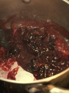 Thick blackcurrant sauce cooked in a saucepan