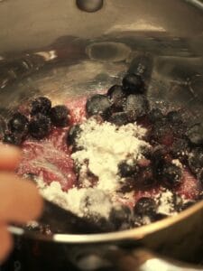 Blackcurrants, sugar, and cornstarch in a saucepan for berry sauce